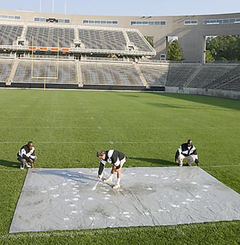 painting elements of the new graphic identity system on the field at Princeton Stadium