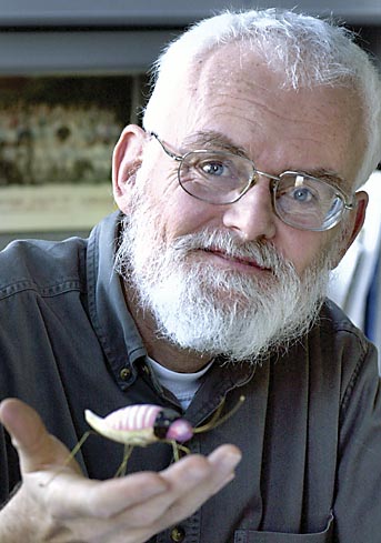 Philip Holmes holds a model of a cockroach