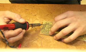 Photo of: A student practices soldering electronic components onto a circuit board
